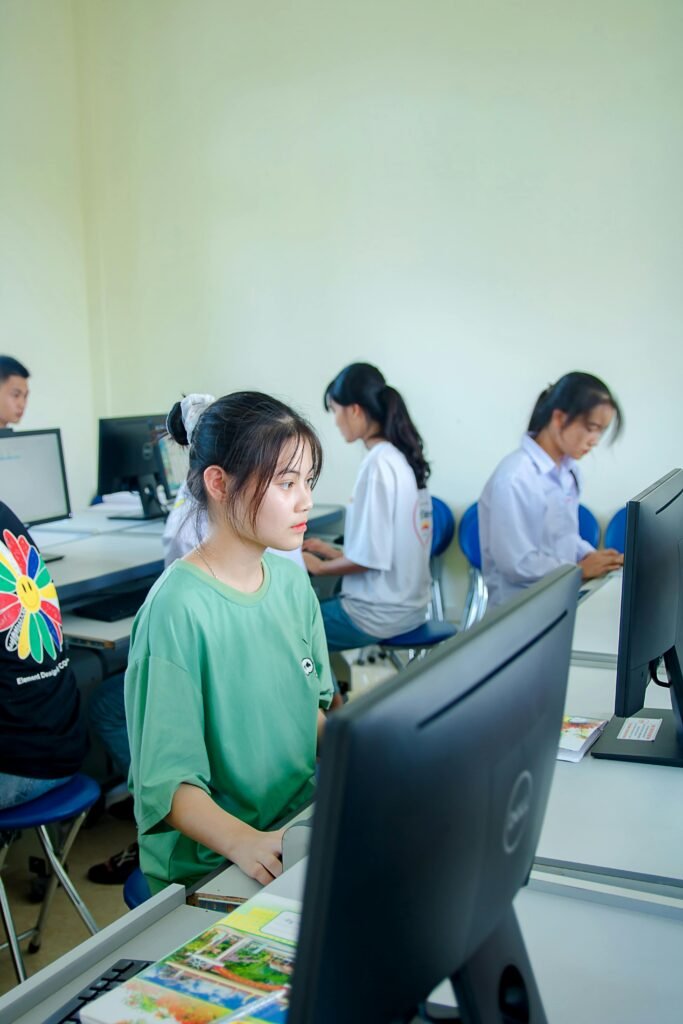 Group of students studying in a computer lab, focused on teamwork and education.