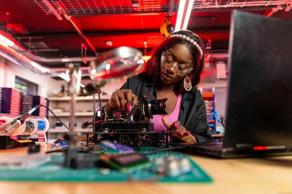 Technical woman expertly repairing electronic device in bright workshop setting.